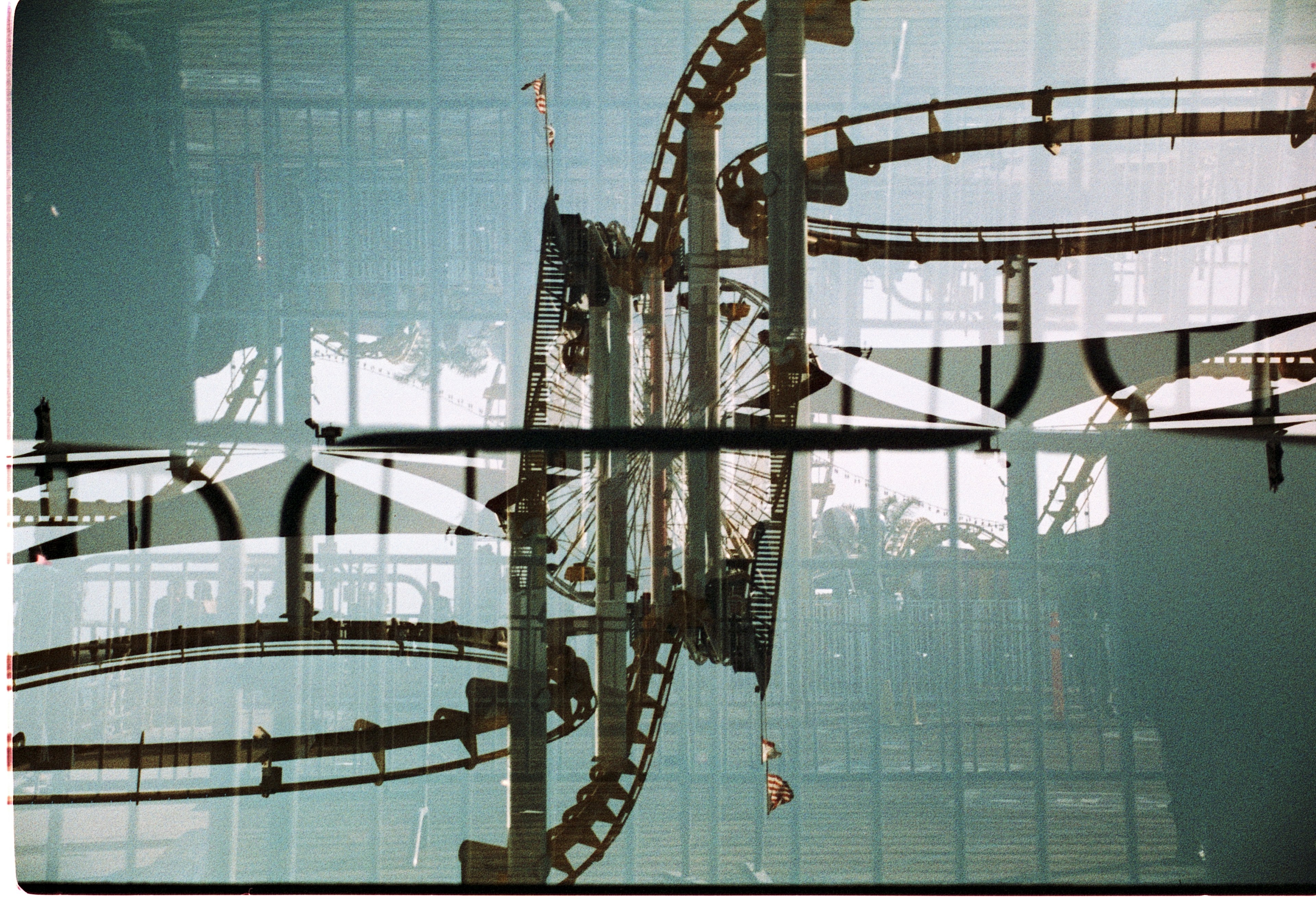 Upside-down roller coaster against a teal and orange sky