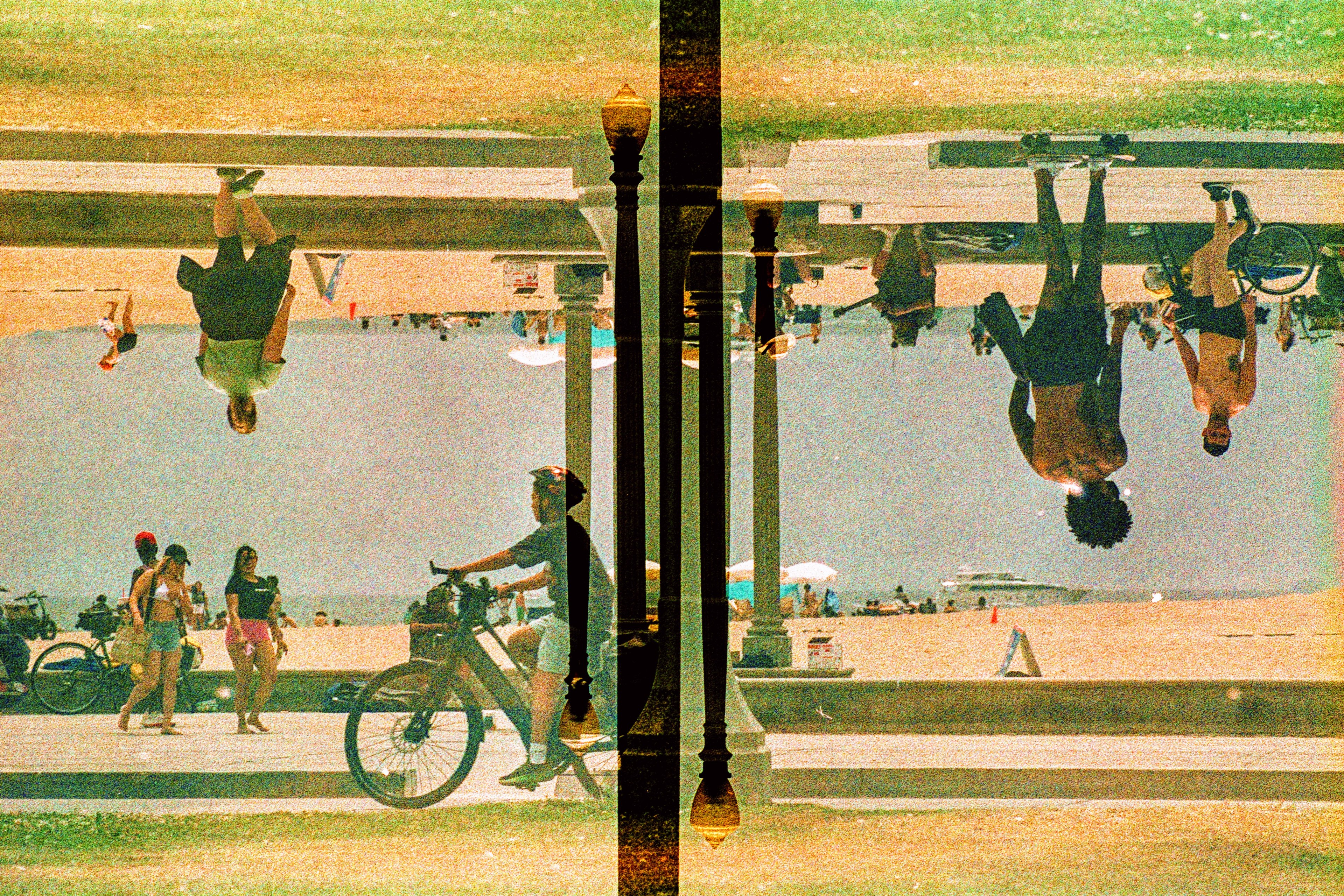 Upside-down beachgoers floating over a boardwalk