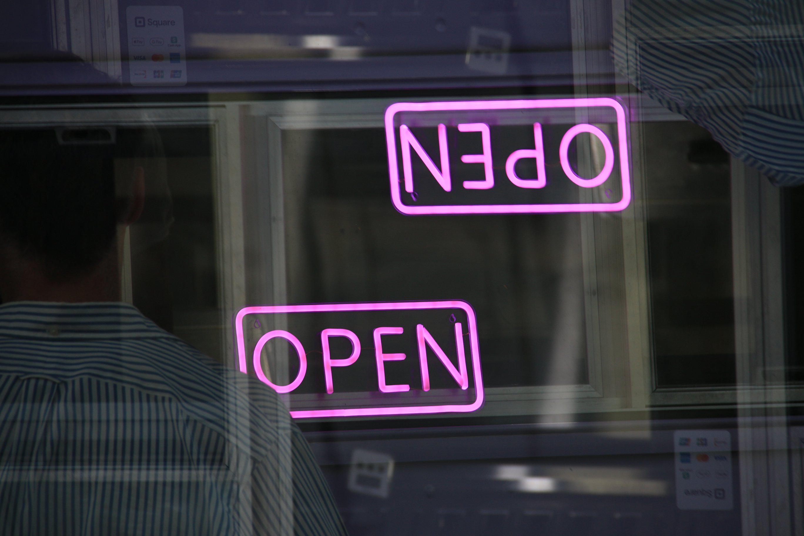 Pink OPEN neon signs layered in opposite orientations